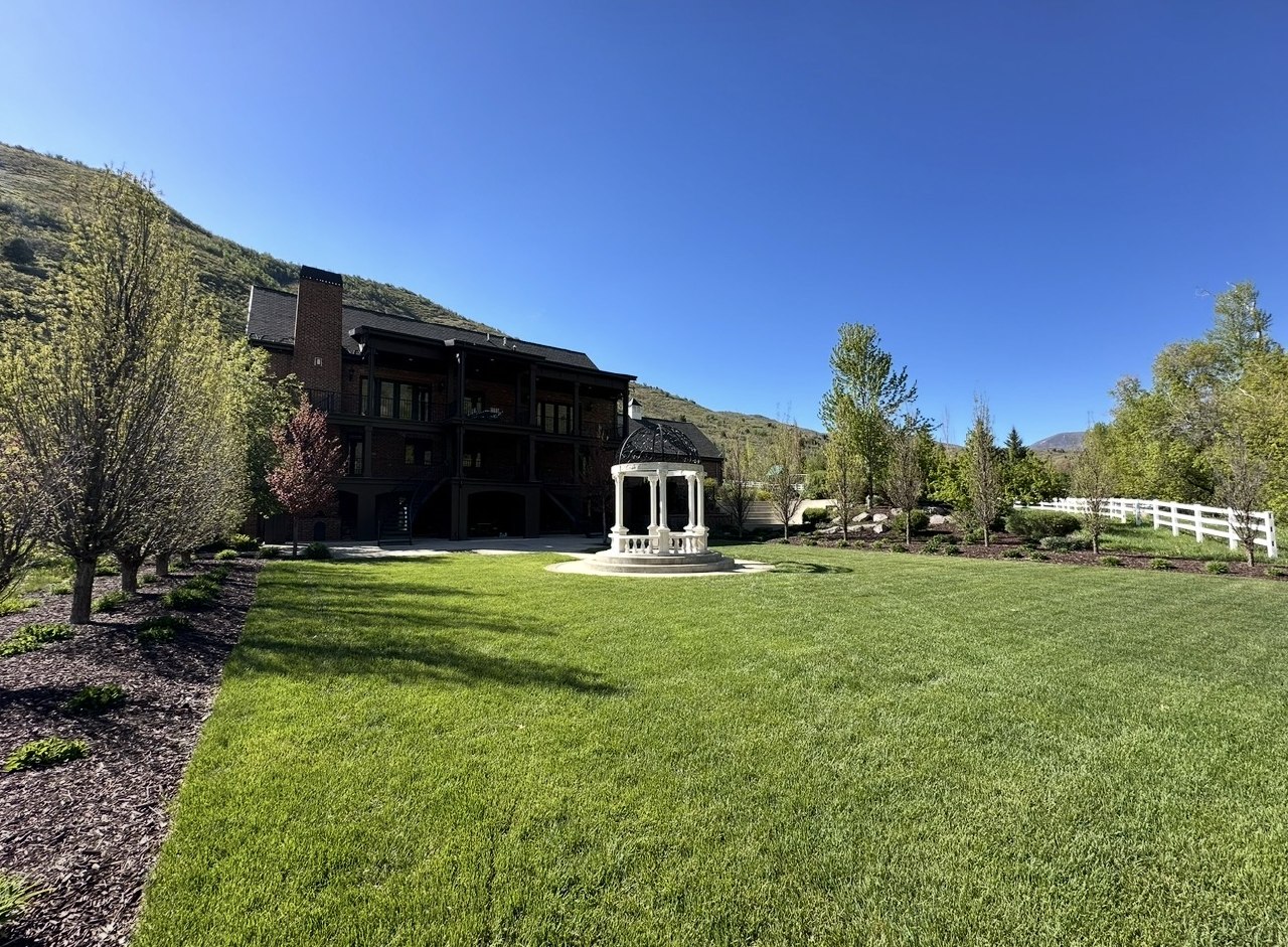 Sprawling estate lawn with gazebo and mountain backdrop